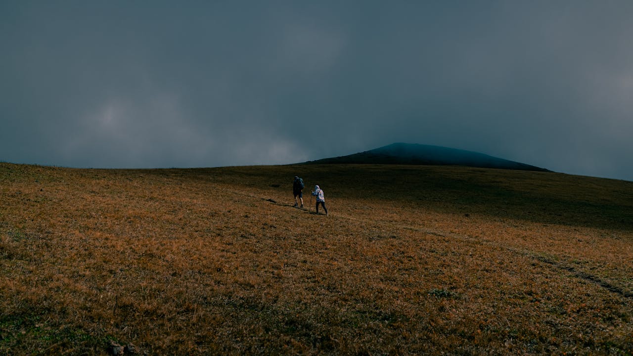 Hikers Ascending Foggy Mountain Landscape